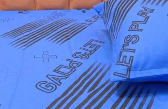 Gaming Zone Bedsheet Single Size displayed on bed showing Let's Play and Game Set text with diagonal stripe pattern in blue and black gaming theme design