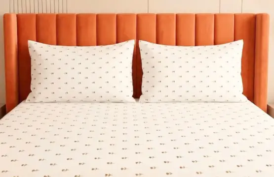 Meadow Whisper cotton bedsheet king size fitted on bed with orange headboard and matching pillow covers